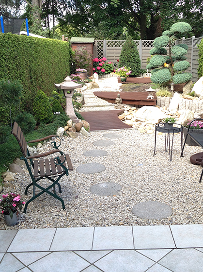Bild eines gepflegten Kiesweges durch einen schmalen Garten